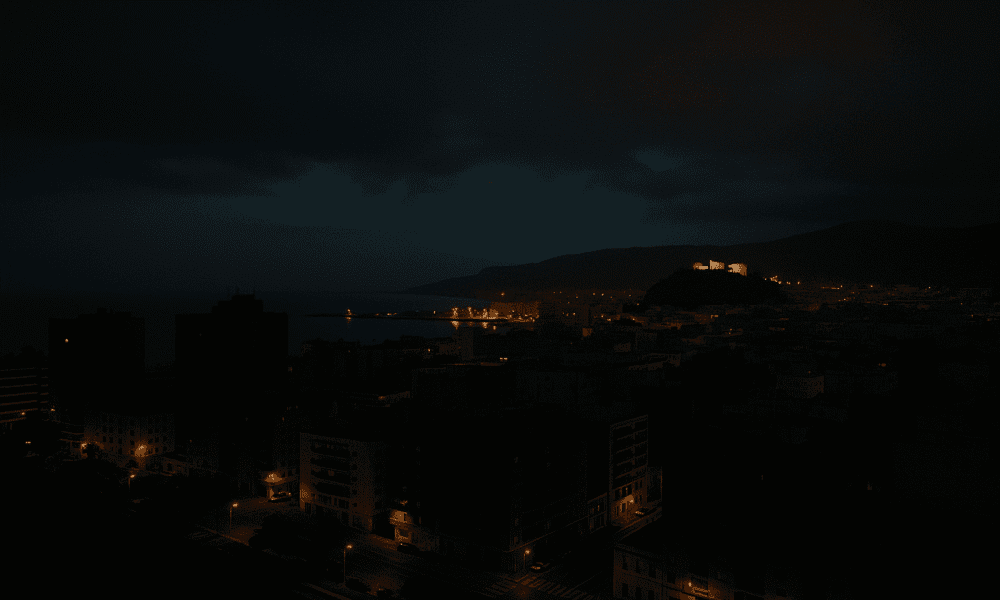 Nighttime view of Almería with partial city lights and illuminated Alcazaba during a power restoration after nationwide blackout