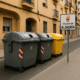 Waste containers and Almería city sign on a residential street during daytime, representing proposed waste fee increase