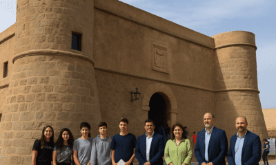 Group of young people and local officials in front of the historic Castillo de San Andrés in Carboneras