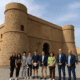 Group of young people and local officials in front of the historic Castillo de San Andrés in Carboneras