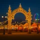 Night view of the All Saints Fair in Albox with illuminated archway, tents and Ferris wheel.