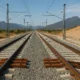 High-speed train track expansion near Almeria, Spain, showing construction work and equipment under clear Mediterranean light.