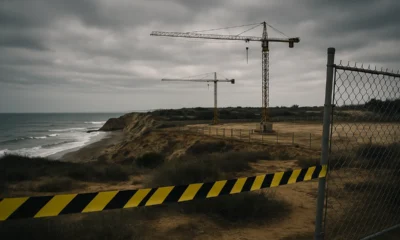 Coastal construction zone with cranes and warning tape near fragile cliffs, representing environmental risks linked to the Palomares PA-4 urbanisation project.