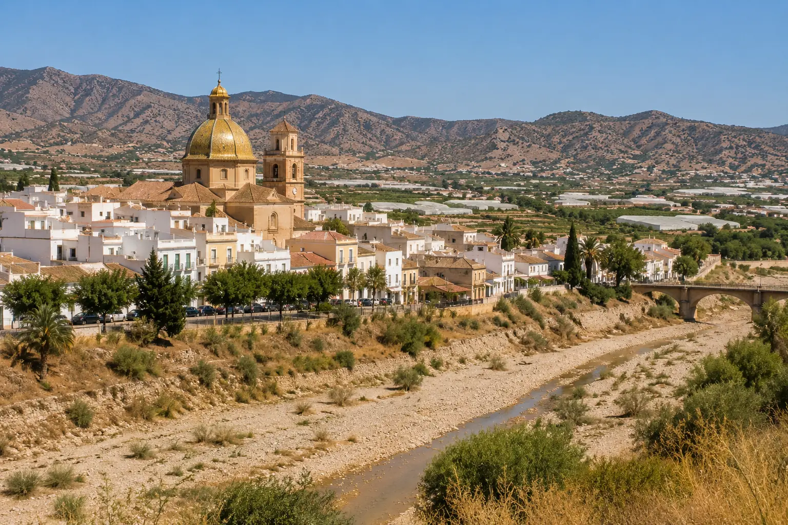 View of Zurgena in the Almanzora Valley with its distinctive golden-domed church and dry riverbed in Almeria province.
