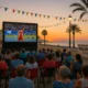 Community watching TVE Grand Prix on large outdoor screen in Balanegra, Almeria at sunset