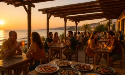 Sunset at a lively seaside chiringuito in Almeria with grilled meats, seafood, and patrons dining outdoors