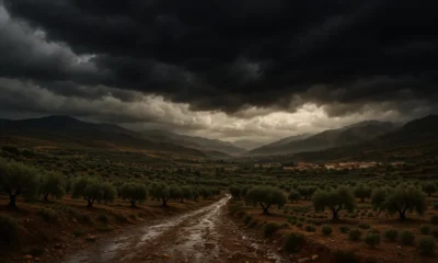 Storm clouds gather over Almeria's Almanzora Valley with rain-soaked hills and villages below.