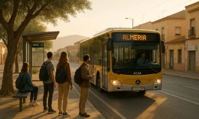 Morning M-102 bus arriving at a quiet Almería city bus stop with few commuters waiting.