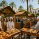 Open-air market in Almeria showing stalls with Roscon de Reyes pastries and festive sweets under natural Mediterranean l