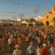 Crowd gathered in the streets of Dalías for Fiestas del Cristo de la Luz in warm Mediterranean light.