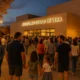 Families and locals arriving for free Disney orchestral concert at Vera Auditorium at dusk